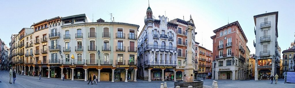 Imagen de la Plaza del Torico en Teruel, con su emblemática fuente central y edificios modernistas que rodean este símbolo del casco histórico.
